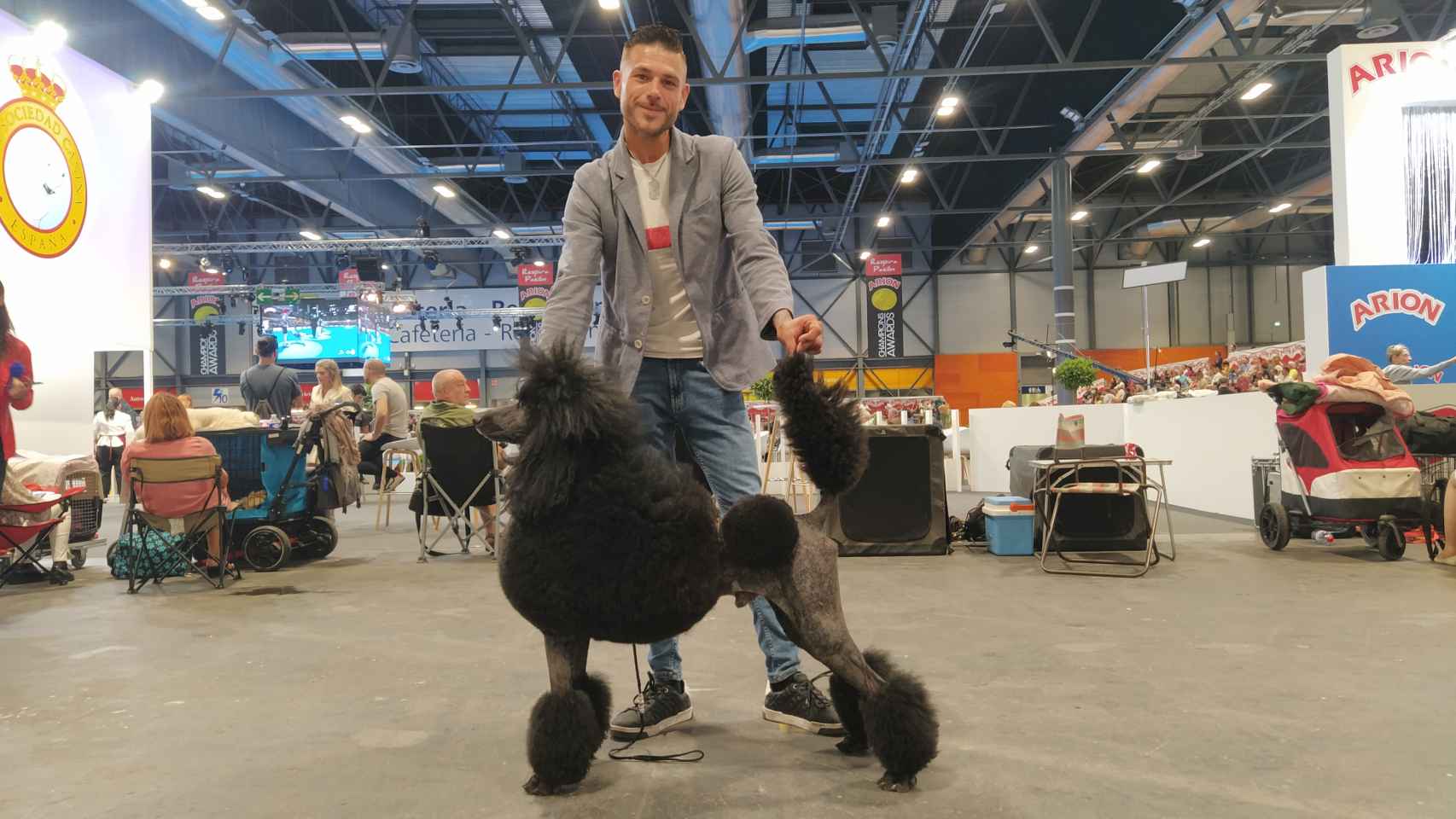El peluquero canino, José Heredia, junto a su caniche gigante, Helmes, en el World Dog Show de Madrid.