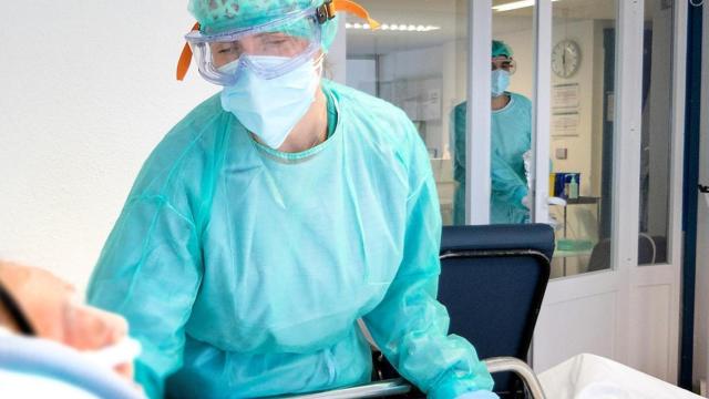 Una sanitaria atiende a un paciente en un hospital de Castilla-La Mancha.