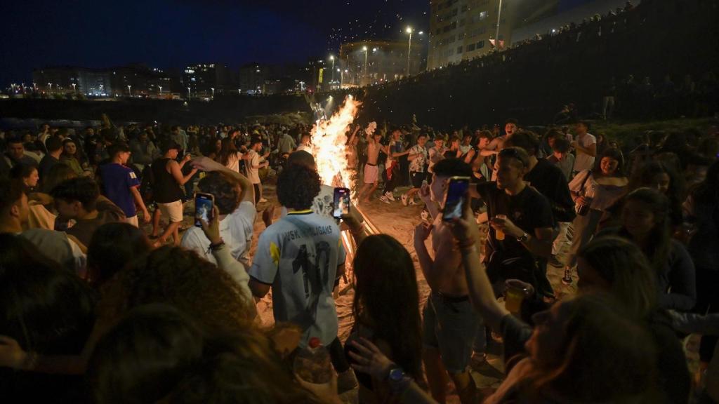 Centenares de personas frente a una hoguera en la noche de San Juan en 2022 en A Coruña.