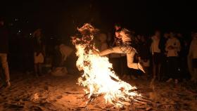 Una persona salta una hoguera en la noche de San Juan de 2022 en A Coruña.