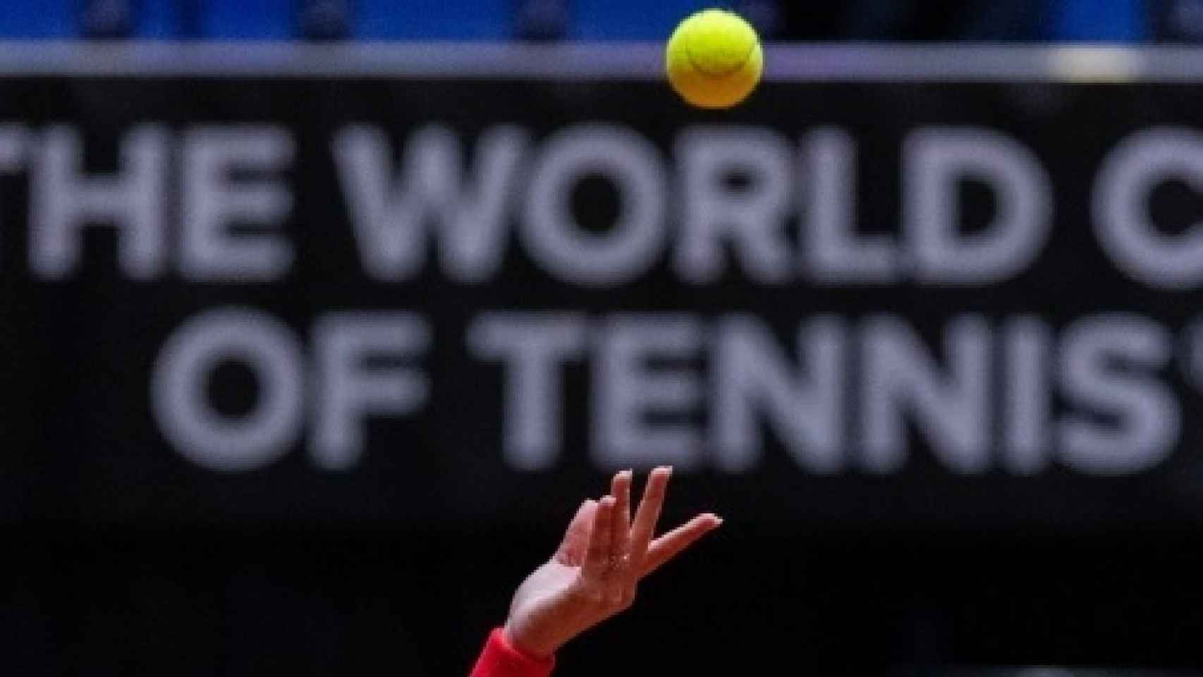 La mano de una tenista tras lanzar la bola para sacar.