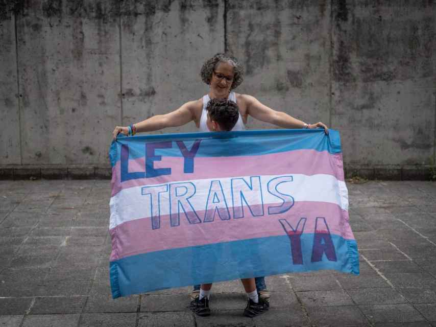 Antonio, un niño al que un juez de Ourense ha autorizado para cambiarse de sexo, envuelto junto a su madre en la bandera trans.
