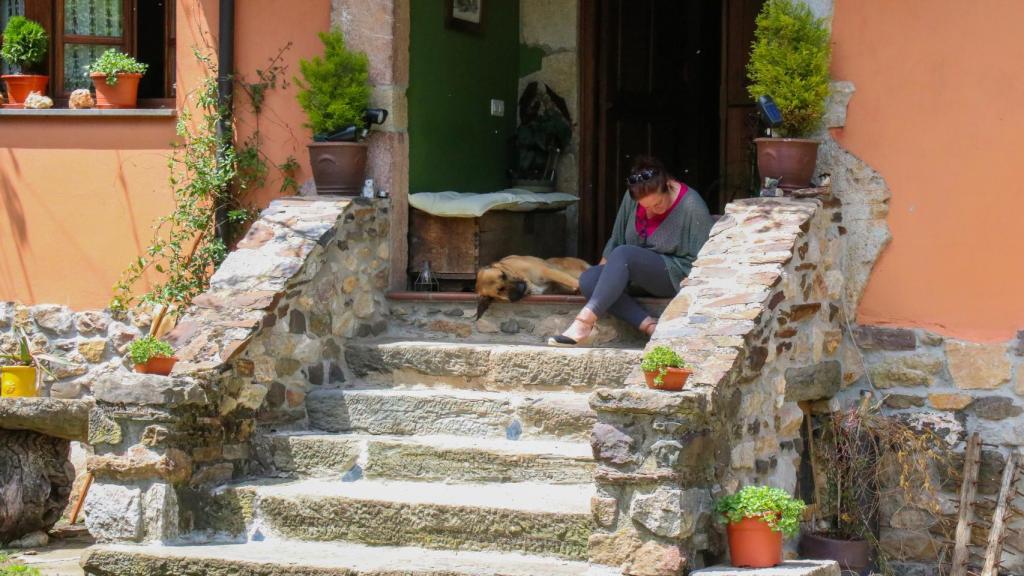 Rosalía, sentada junto a su perra Tosca frente a sus apartamentos en el Coto de Buenamadre