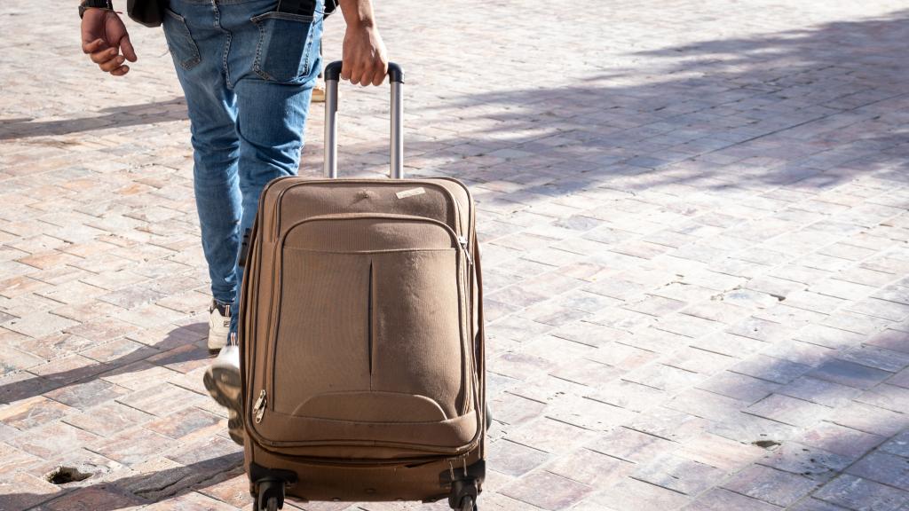 Un turista llevando una maleta.