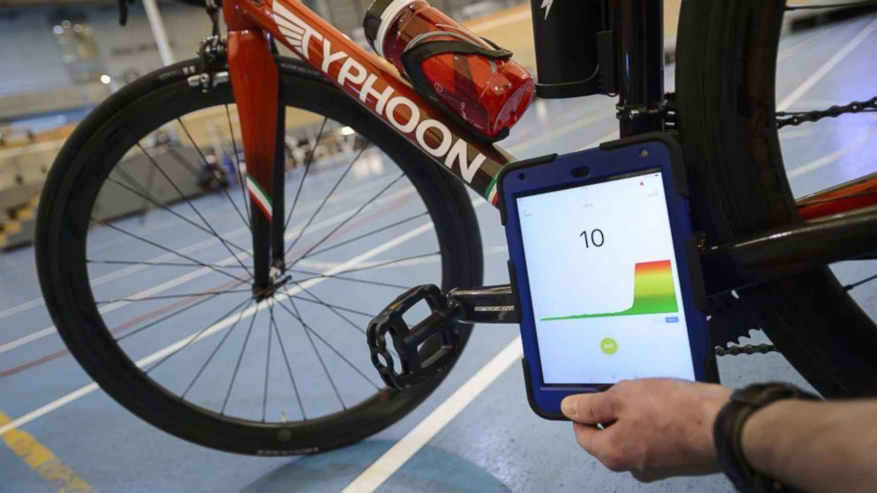 Un miembro de la UCI revisa una bicicleta que lleva un motor con la aplicación especial de sus tablet.