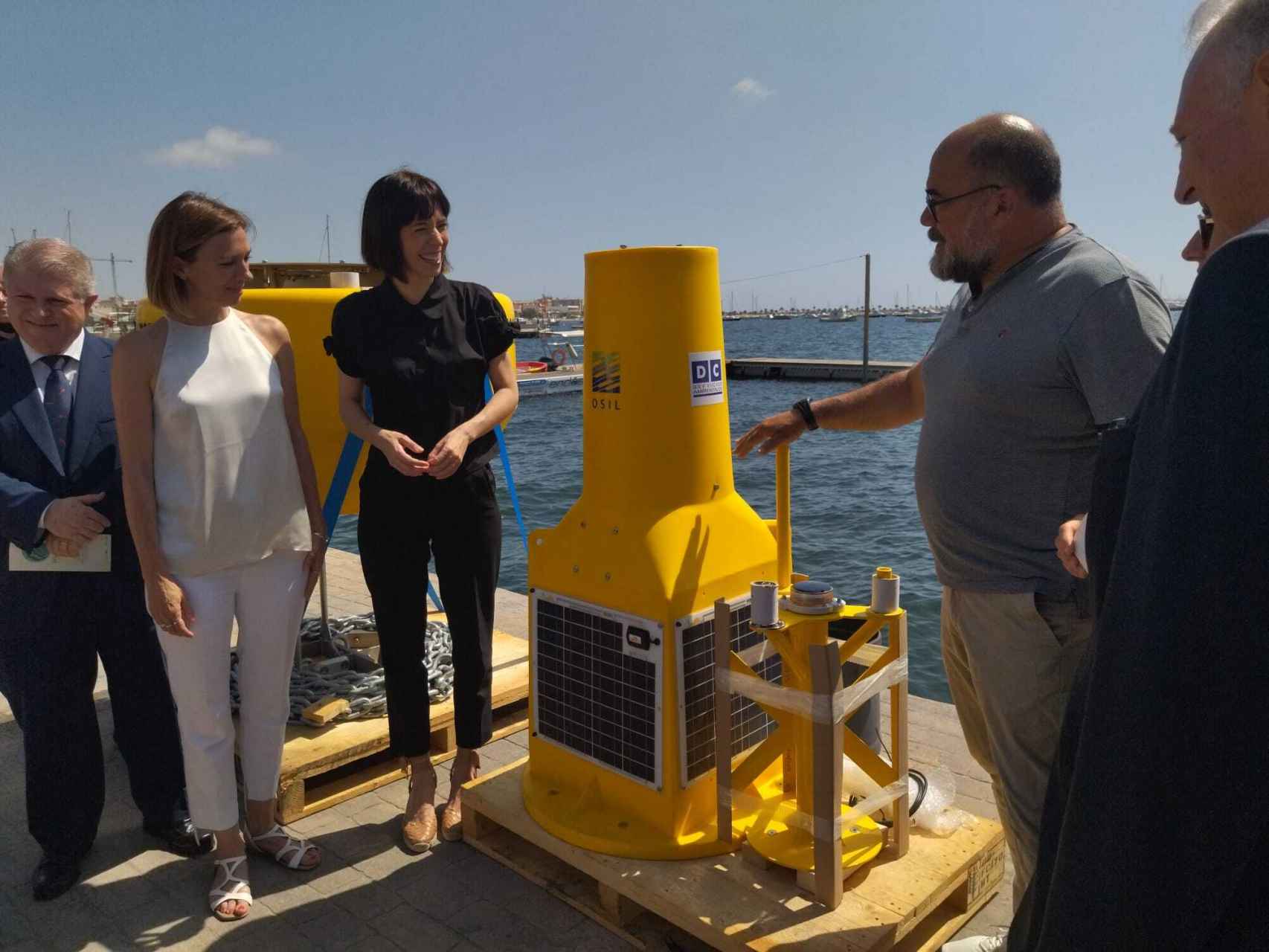 Juan Manuel Ruiz, profesor de investigación del Instituto Español de Oceanografía (IEO), este jueves, mostrando a la ministra de Ciencia, Diana Morant, una de las boyas con sensores que analizará el ecosistema del Mar Menor.