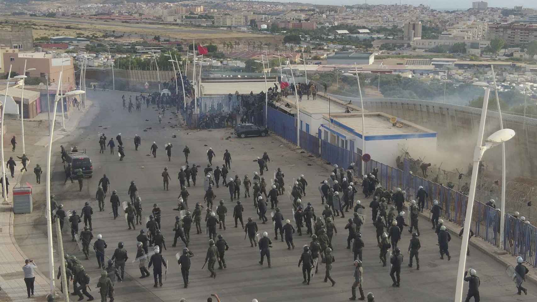 Policías marroquíes intervienen en la frontera con Melilla para detener a los migrantes que intentaban atravesarla hacia España, el 24 de junio.