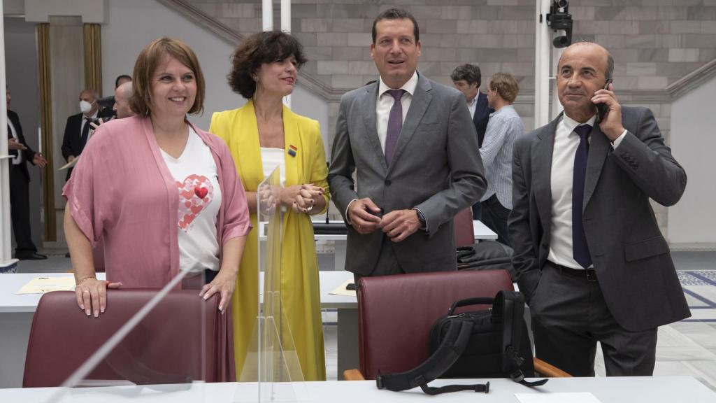 La diputada del PSOE Lara Hernández, vestida de amarillo, junto a compañeros de bancada en el Hemiciclo.