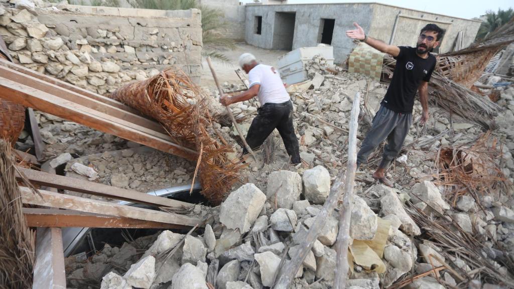 Dos hombres buscan entre los escombros de su vivienda tras uno de los terremotos que han sacudido Irán este sábado 2 de julio