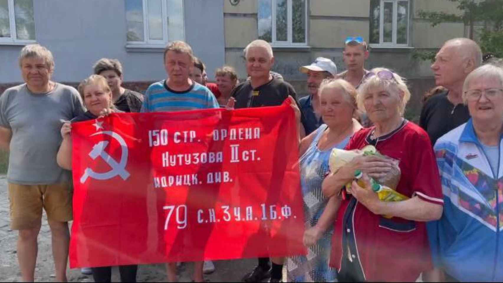 Ciudadanos de Lisichansk reciben a las tropas rusas con una bandera sociética.