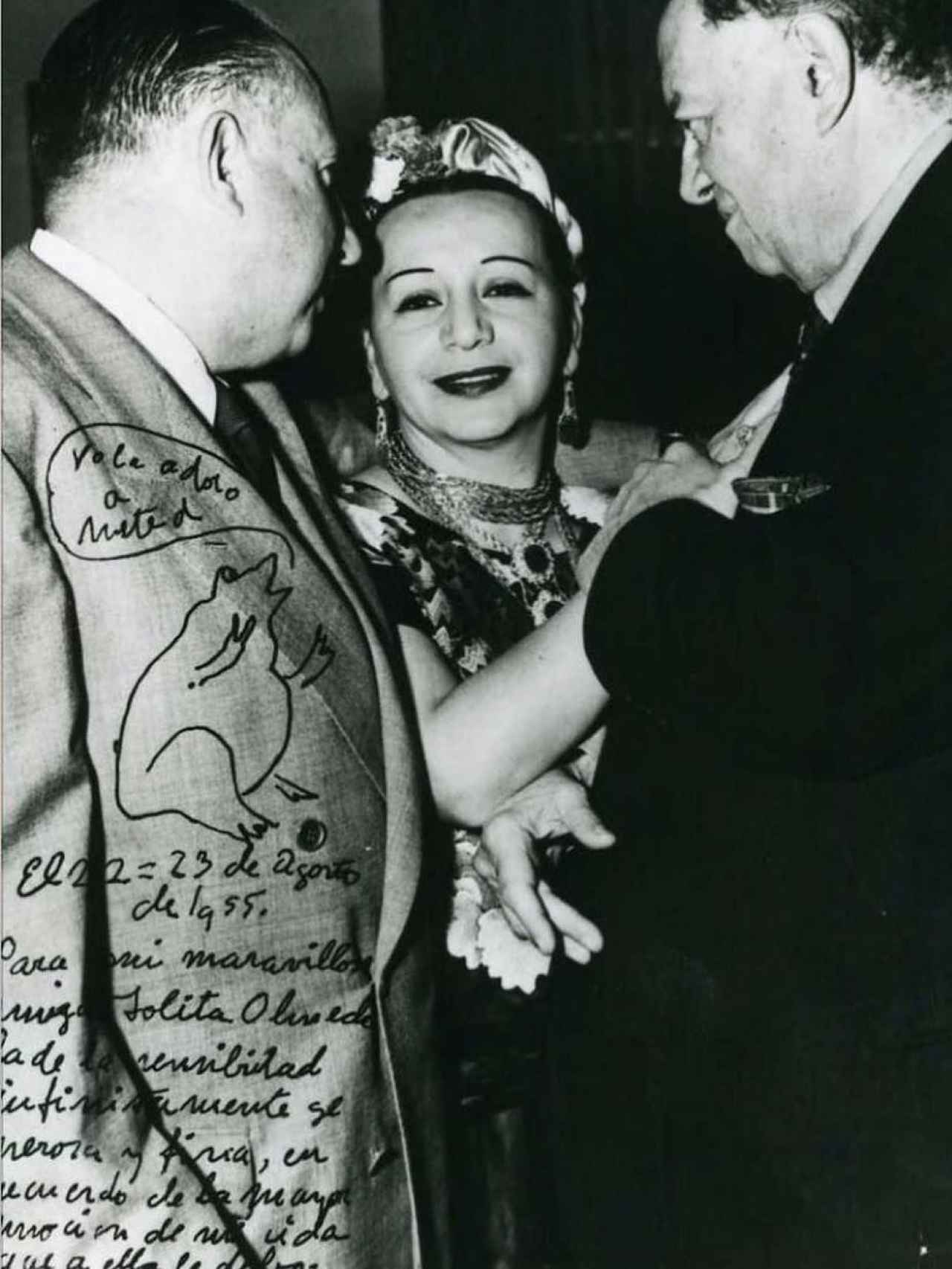 Dolores Olmedo, en 1955, con el diputado Antonio Vargas McDonald y Diego Rivera (dcha), en una foto dedicada por este, que firma como el sapo.