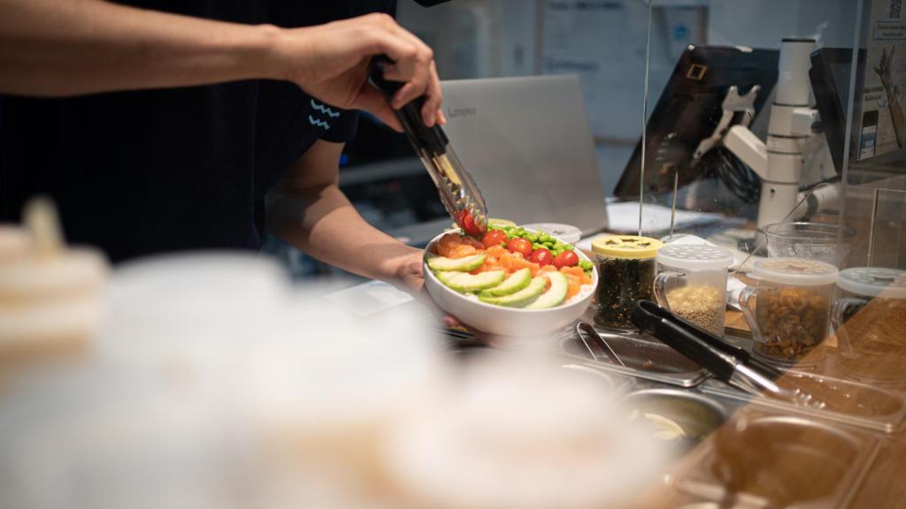 Un trabajador de Aloha Poké, preparando un plato de poké.