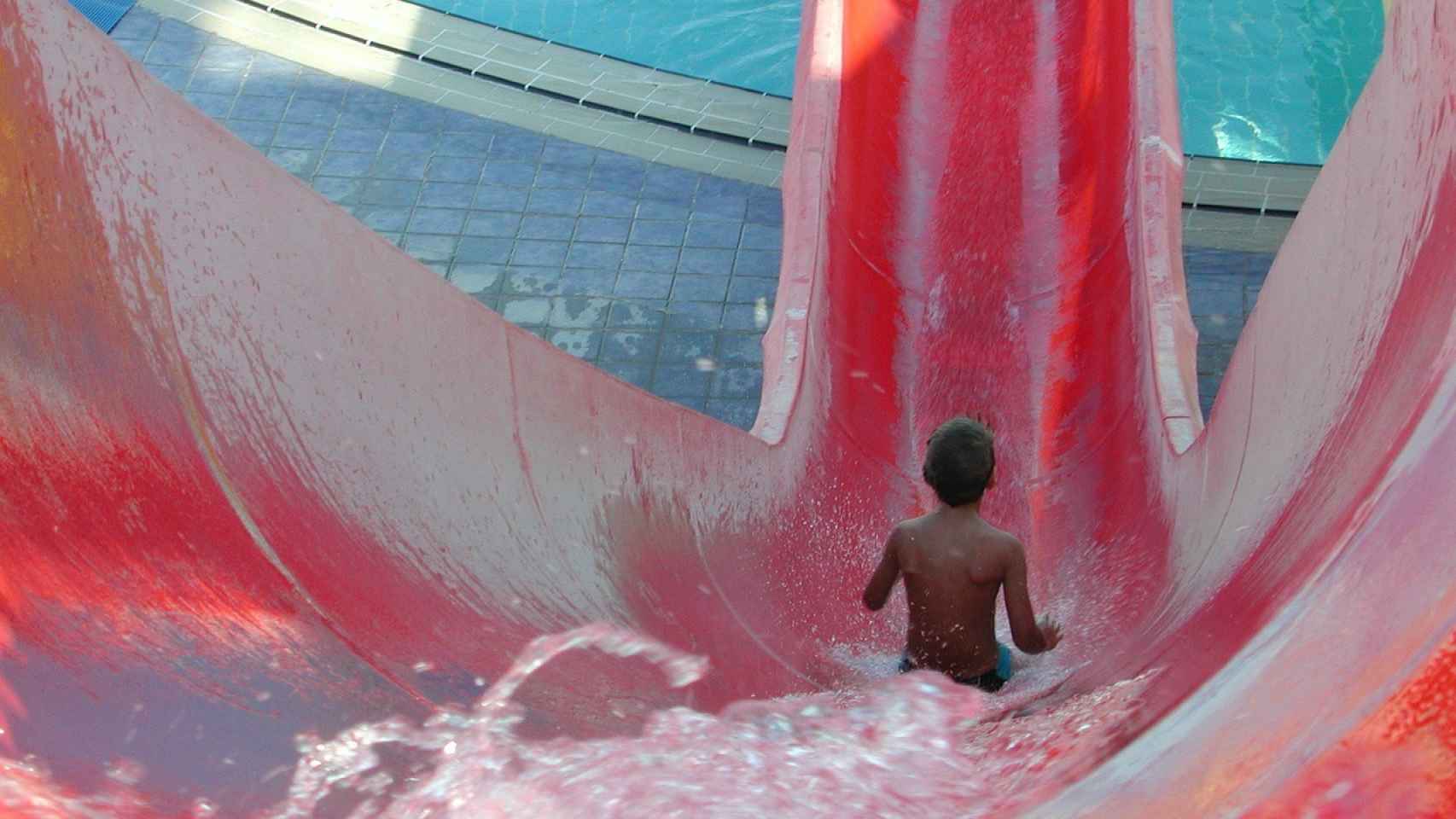 Un niño disfruta de un tobogán en un parque acuático.