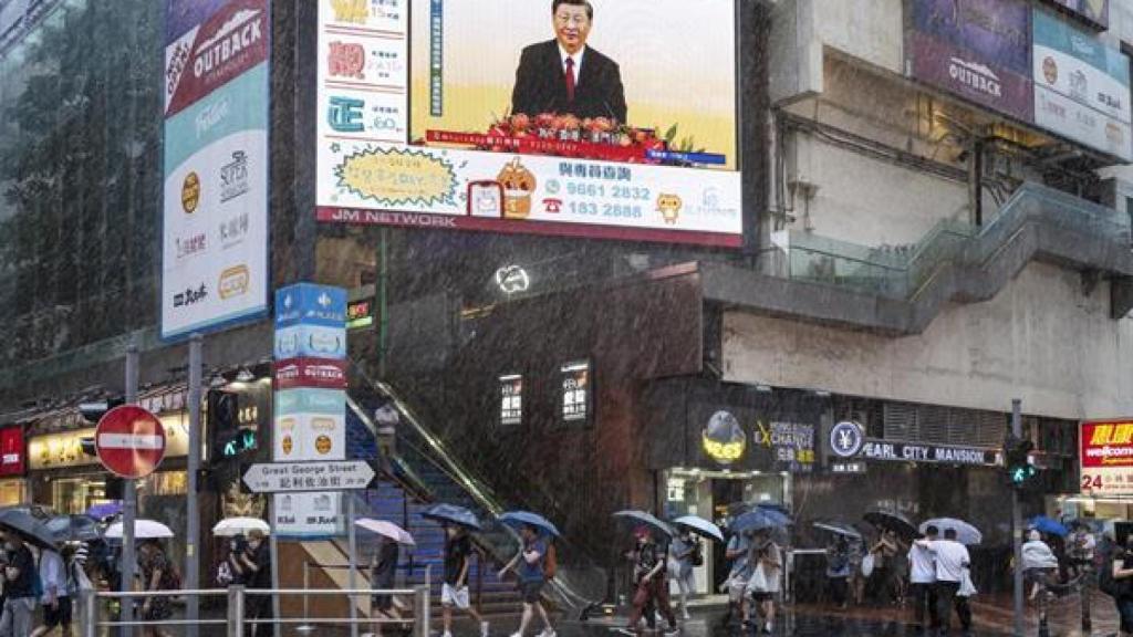 Calle de Hong Kong con una pantalla que muestra al presidente chino, Xi Jinping, hablando durante una ceremonia de juramento del nuevo director ejecutivo de Hong Kong, John Lee, en Hong Kong, China, el 1 de julio de 2022.