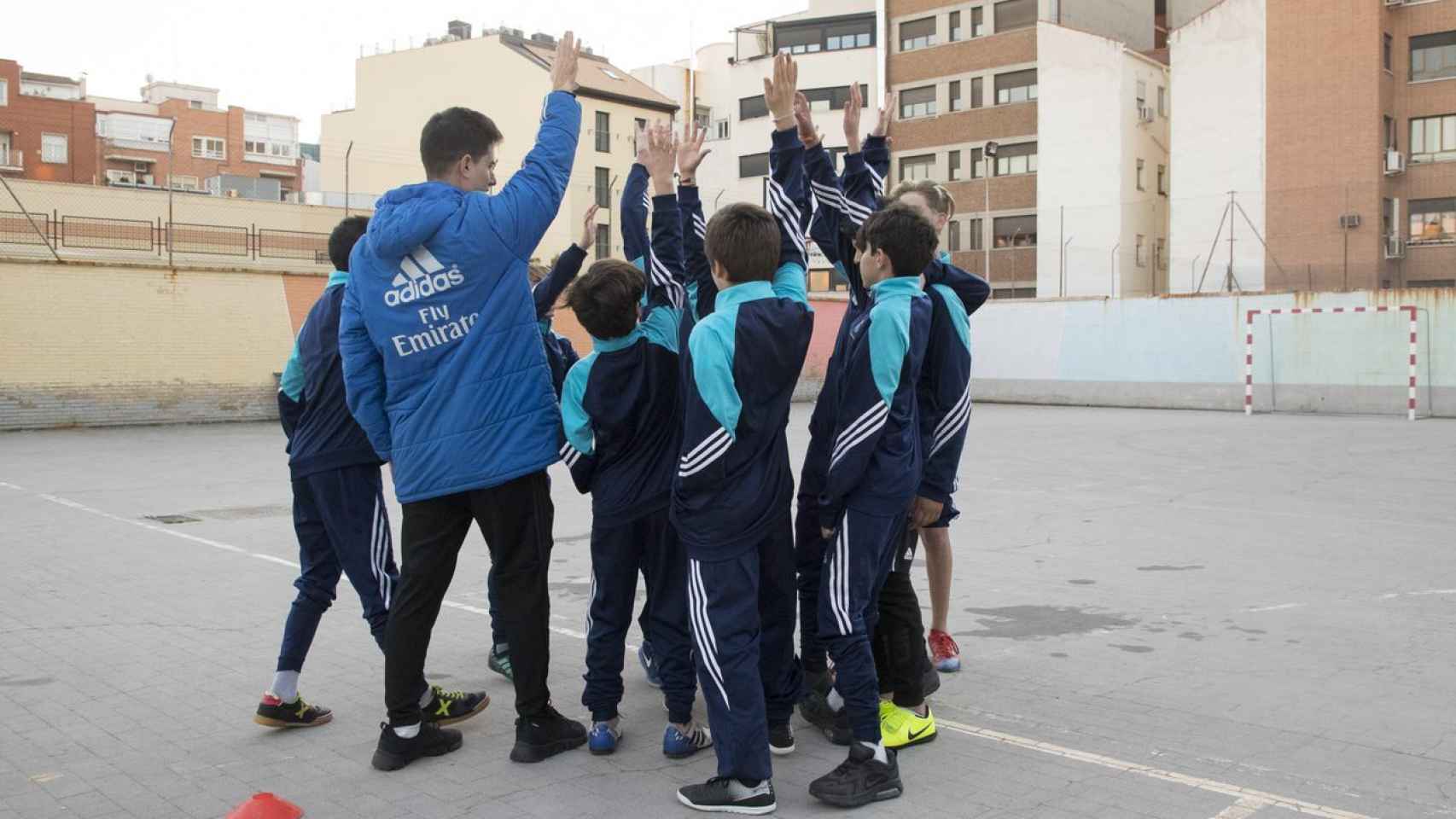 Un grupo de jóvenes con su entrenador participan en el programa de la Fundación Real Madrid.