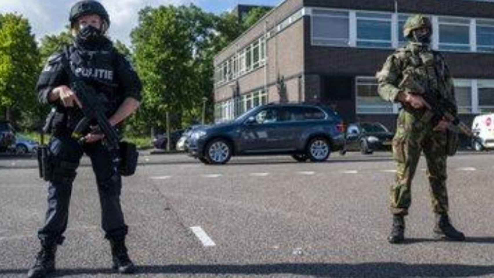 Un policía de la unidad de intervención especial y un militar neerlandés custodiando el Tribunal que juzga a la organización de Taghi