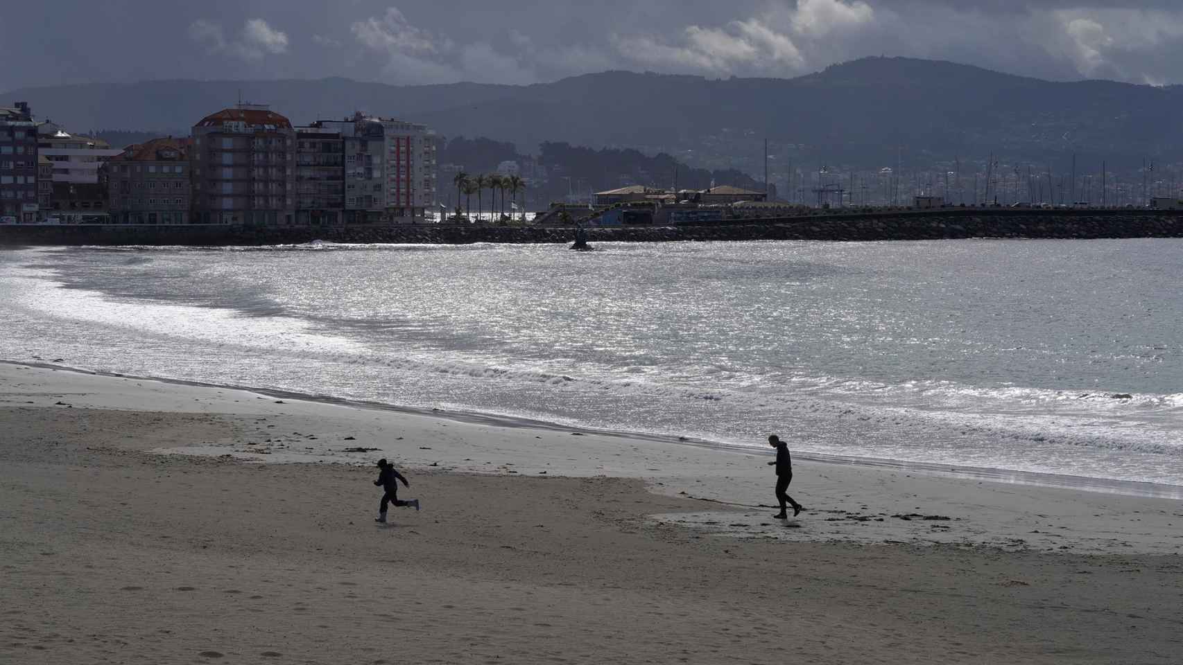 Varias personas pasean por la playa de Silgar en Sanxenxo.