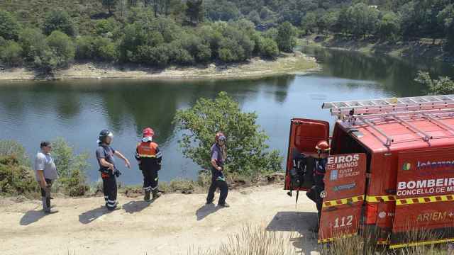 Efectivos de bomberos en el lugar donde ha caído un camión al agua tras realizar tareas de desbroce, en el embalse de As Conchas, en Muíños, Ourense, Galicia (España). El hecho se produjo cuando el camión cayó al río Limia cuando circulaba por una pista forestal.