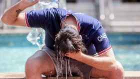 Un joven se tira una botella de agua por encima para combatir la segunda ola de calor del verano, a 12 de julio de 2022, en Madrid (España).