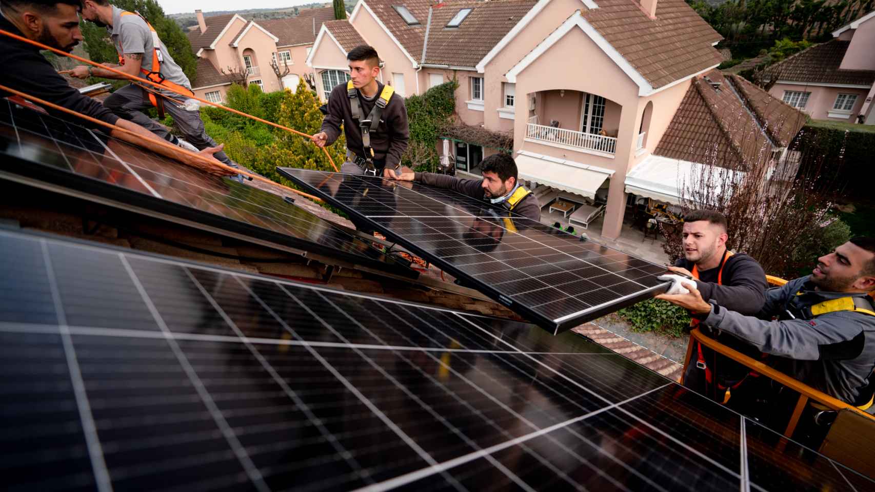 Operarios instalan paneles solares en una vivienda
