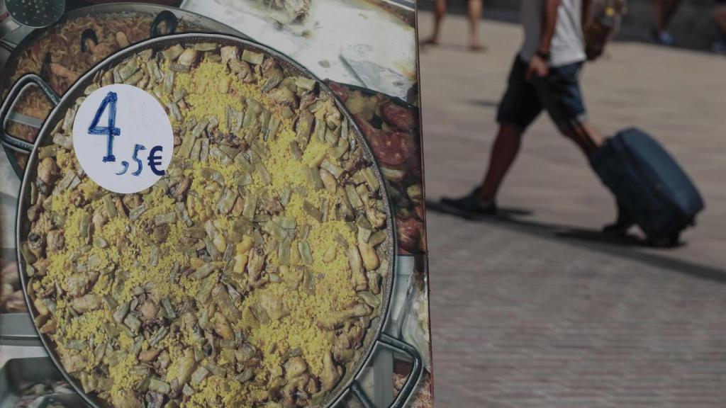 Un turista pasa por delante de un restaurante en Valencia.