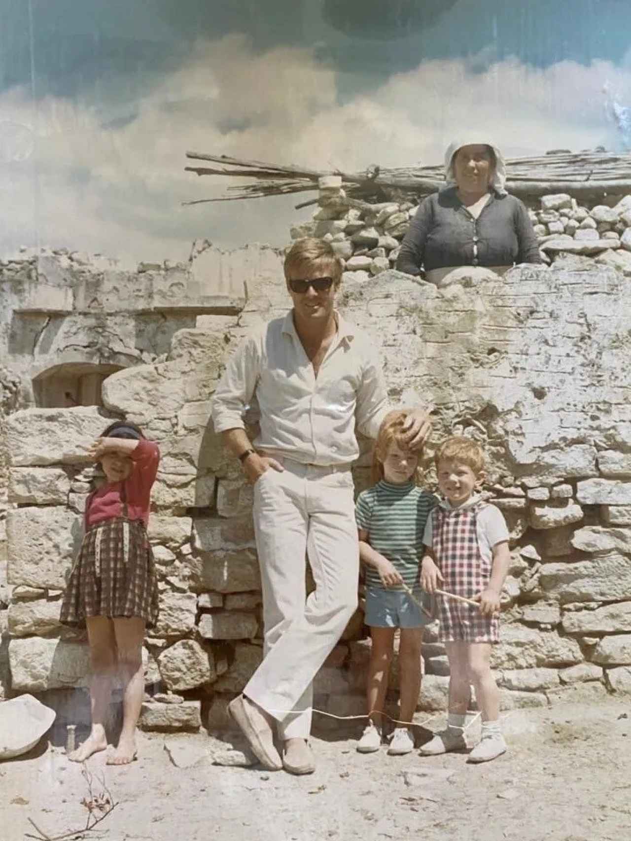 Redford junto a sus dos hijos y dos vecinas de Mijas, frente a una indeterminada casa de la localidad..