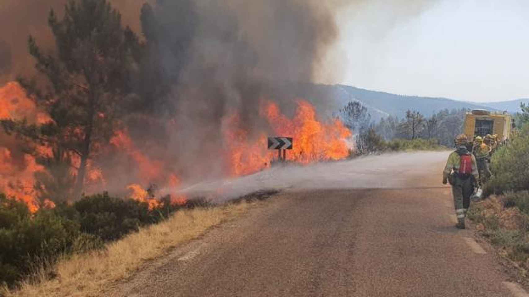 Los bomberos atacan al fuego junto a una carretera en las Batuecas.