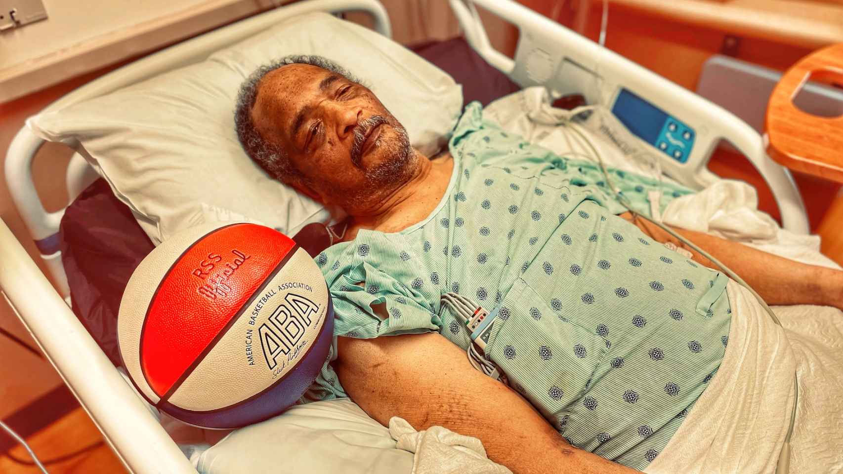 Sam Smith postrado en una cama de hospital y a su lado un balón de la mítica ABA