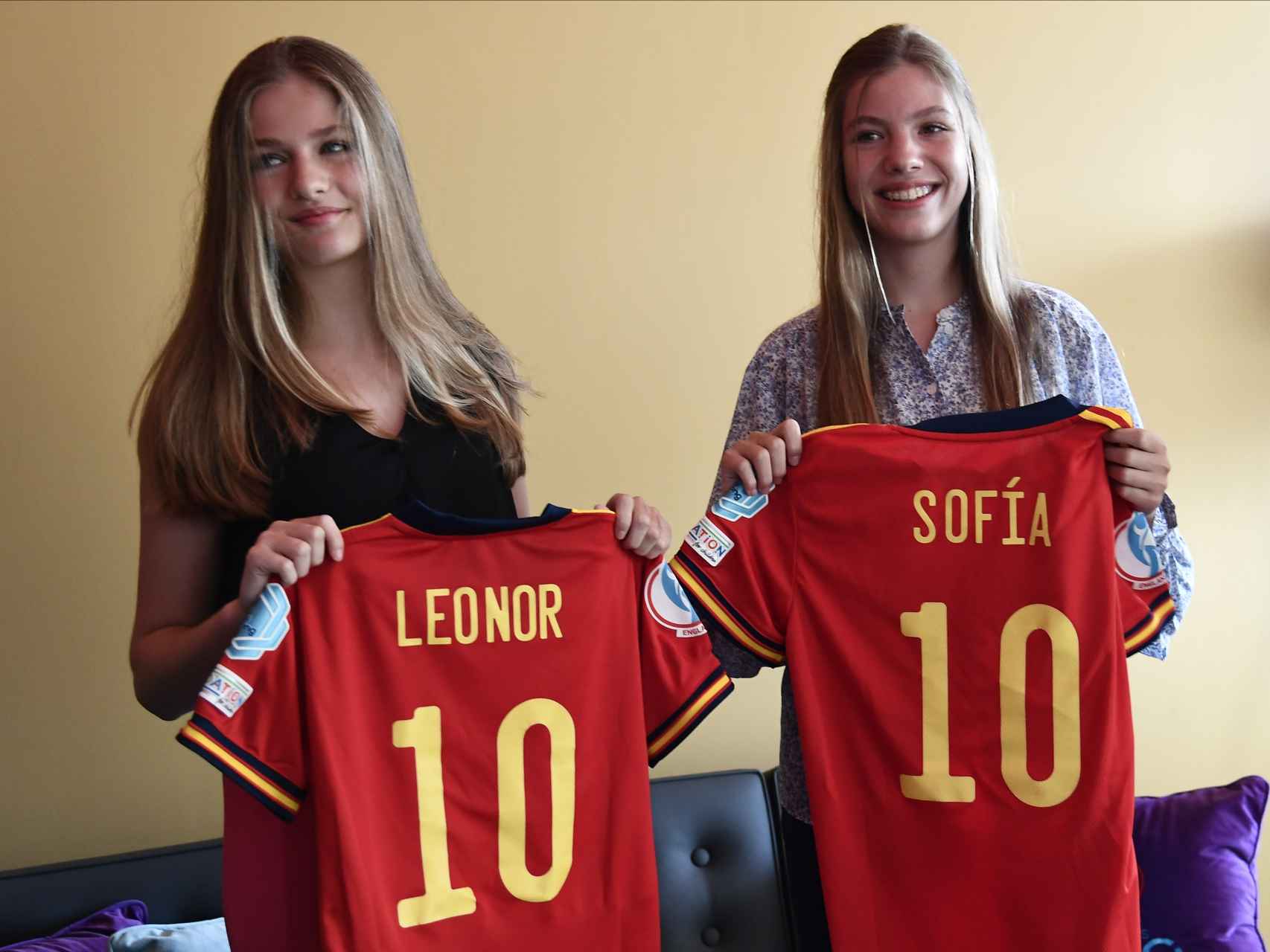 Leonor y Sofía recibiendo la camiseta de la selección española con sus nombres.