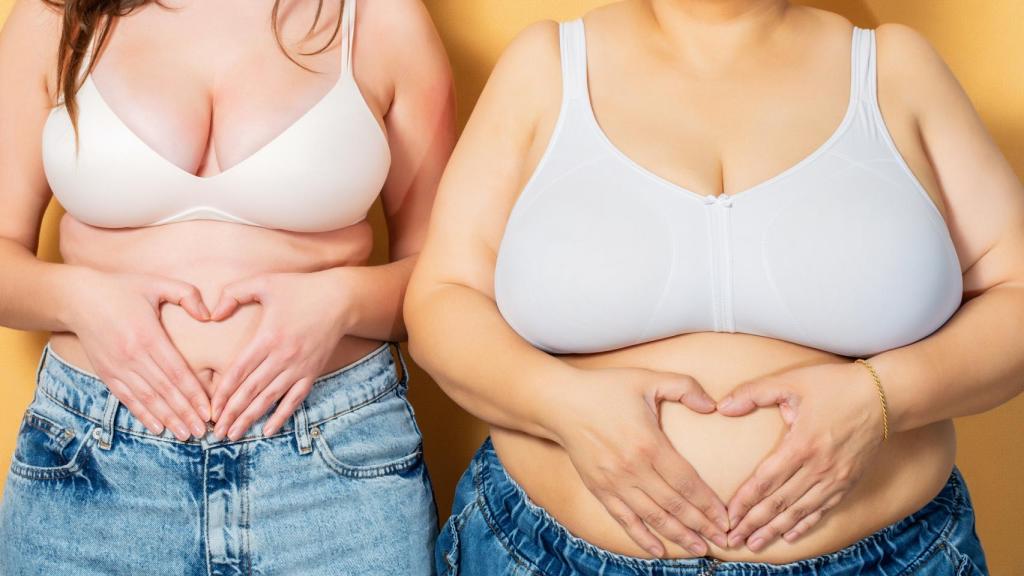 Imagen de archivo de dos mujeres con cuerpos diferentes que posan formando un corazón con las manos.