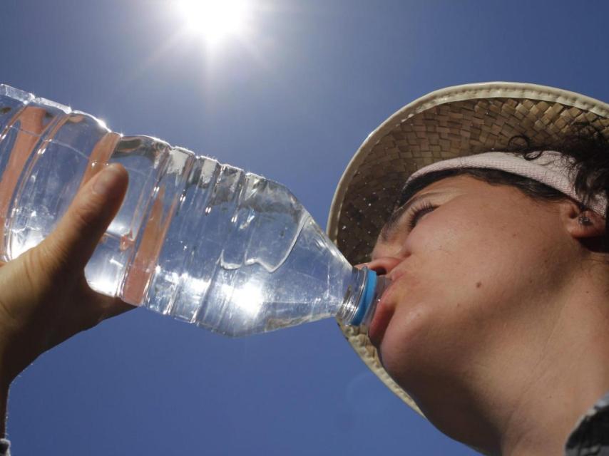 Una mujer bebiendo agua embotellada