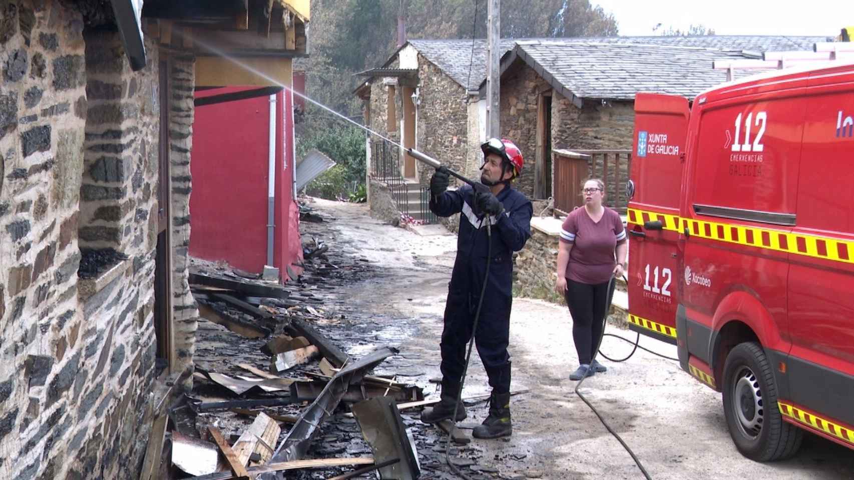 Un bombero enfría una vivienda arrasada por el fuego en Alixo, O Barco de Valdeorras (Ourense).