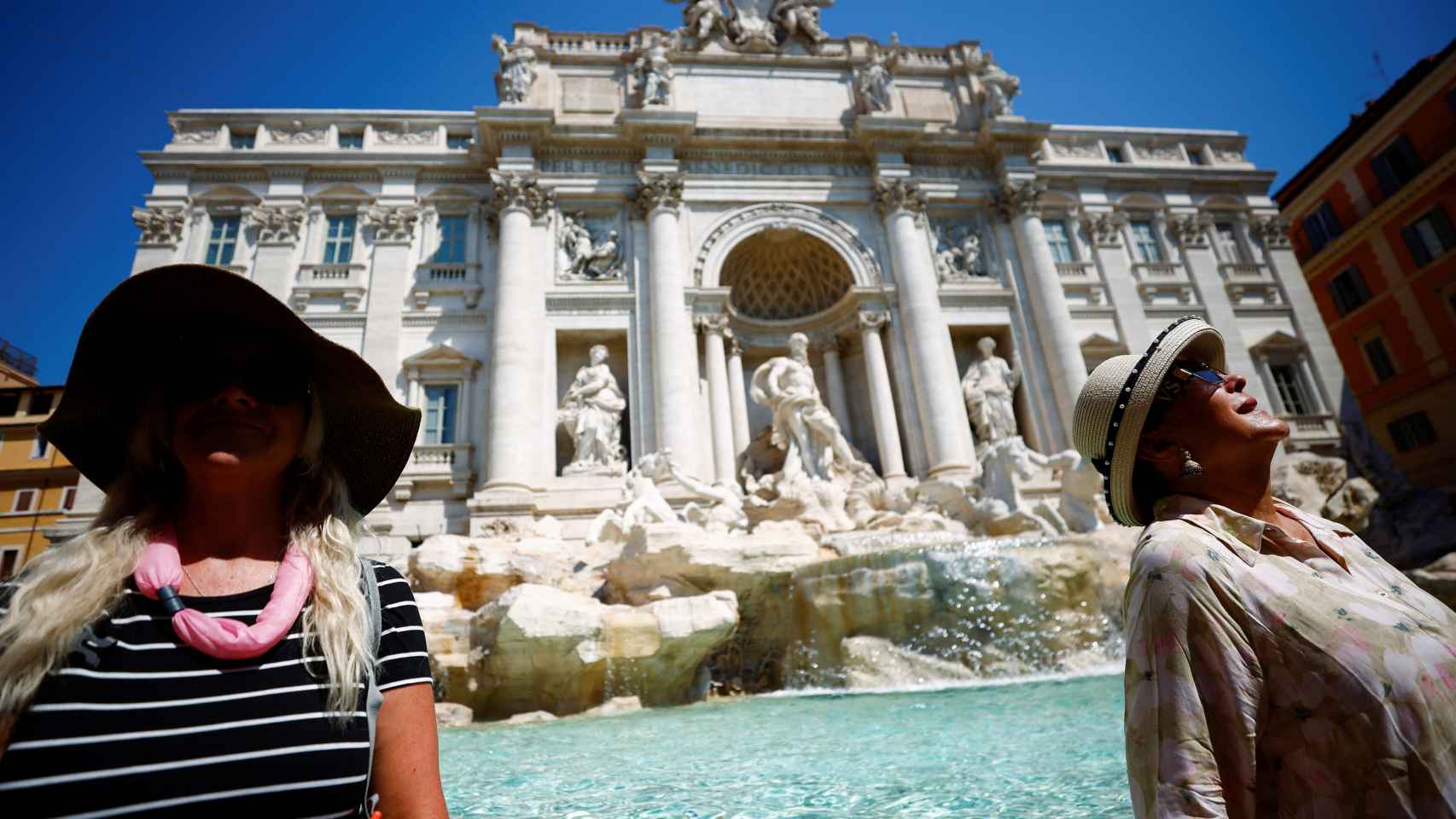 Unas turistas se refrescan en la Fontana de Trevi.