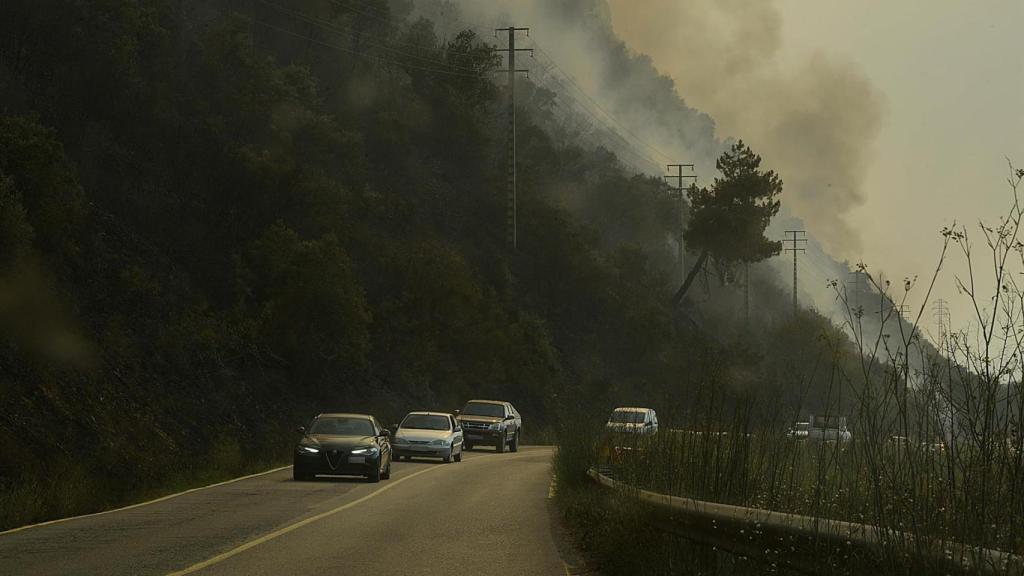 Varios coches desalojan la zona debido al incendio en el municipio en O Barco de Valdeorras, Ourense.