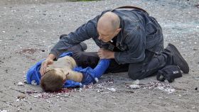 Un padre sujeta la mano de su hijo que acaba de morir en Járkov.