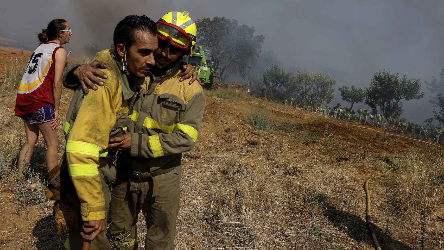 Dos brigadistas exhaustos durante las labores de extinción del incendio en Faramontanos de Tabara, Zamora