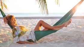 Mujer relajándose en una hamaca en la playa