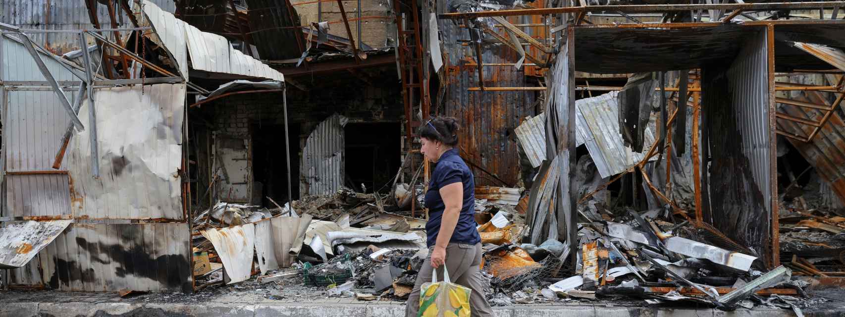 Una mujer pasa por delante de un mercado destruido por los ataques rusos en Donetsk