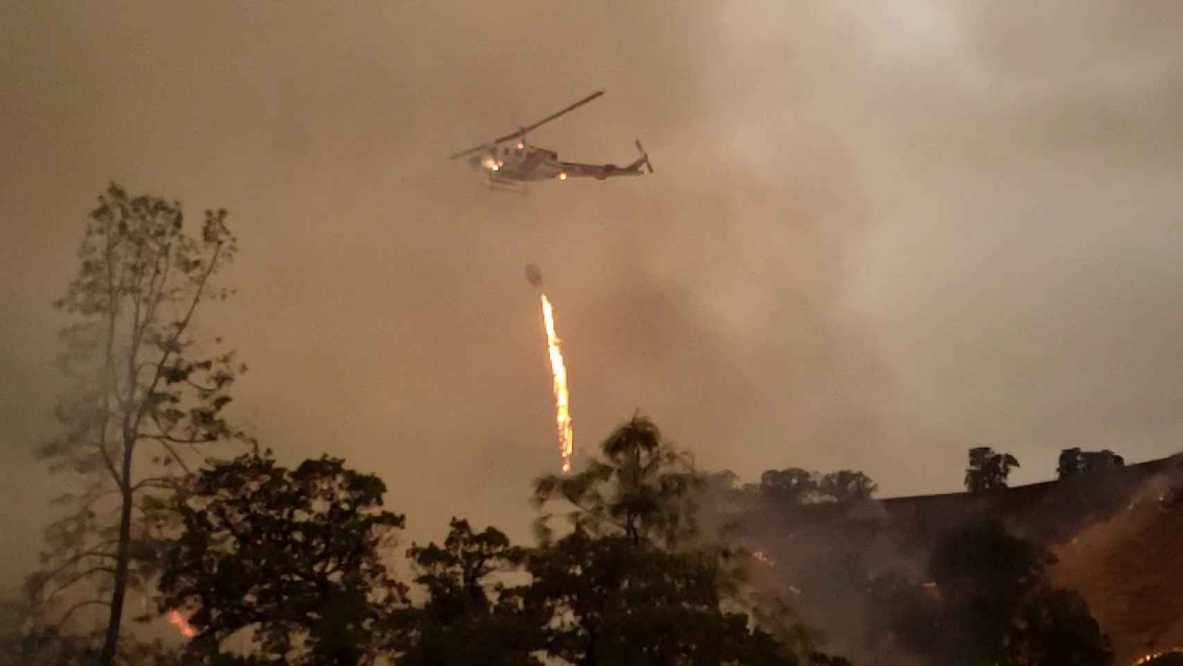 Helicóptero lanzando fuego sobre un bosque