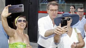 Dos turistas se hacen un selfi con Alberto Núñez Feijóo, el viernes durante su visita a Benidorm.