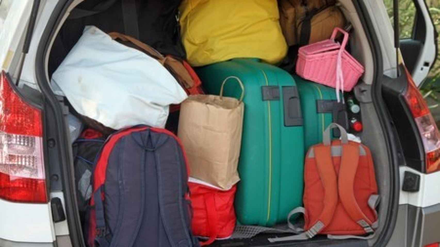Un maletero cargado de mochilas y maletas.