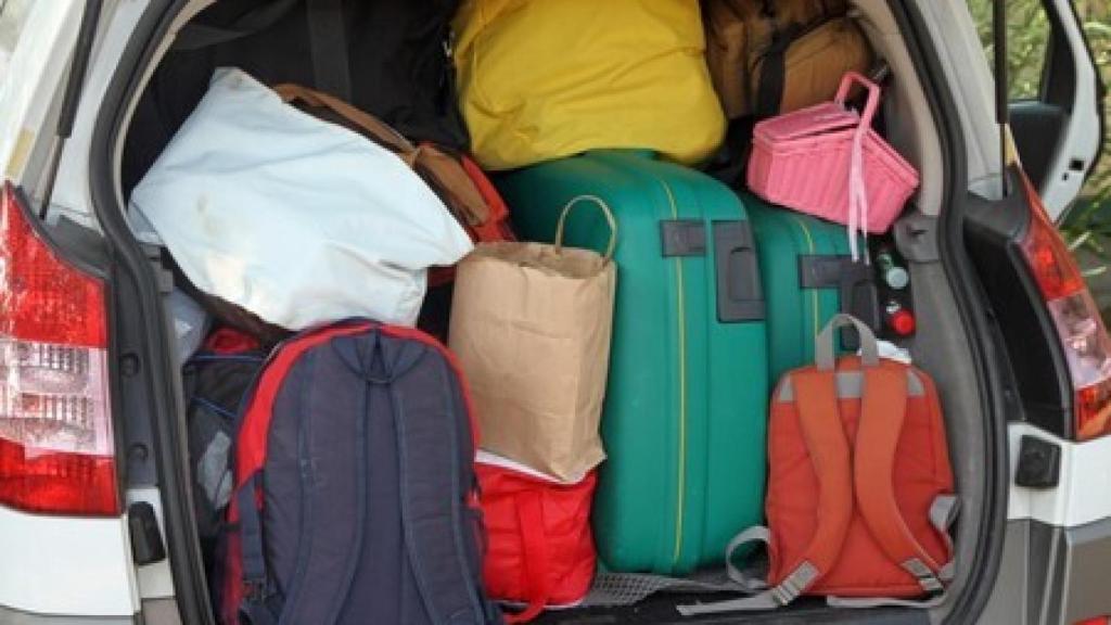 Un maletero cargado de mochilas y maletas.