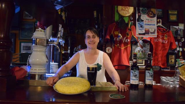 Charo Gutierrez Olmedo tras el mostrador del Seamróg con una tortilla y una pinta Guinness