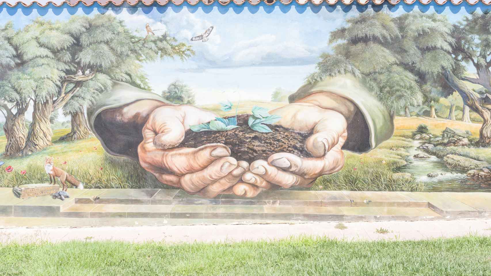 Mural en la plaza del pueblo italiano de Usaramanna en Cerdeña con la inscripción en tus manos, nuestro futuro.