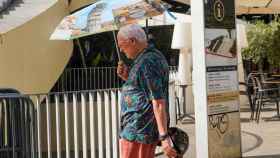 Un turista con un paraguas por la Setas en otro día con altas temperaturas en Sevilla.