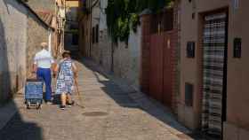 Una pareja de ancianos camina por el municipio madrileño de Torrelaguna.