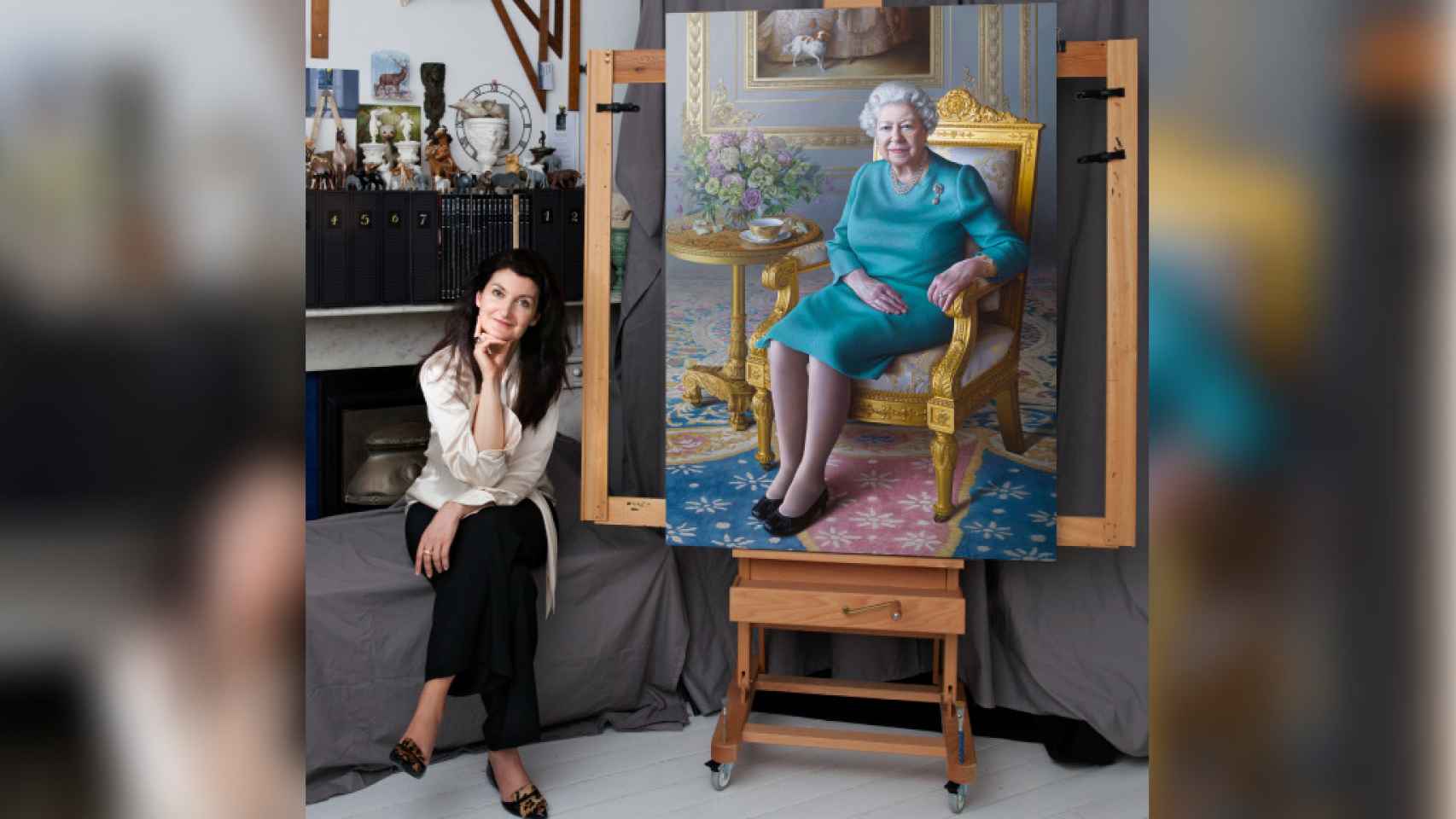 La pintora Miriam Escofet, junto a su retrato de Isabel II.