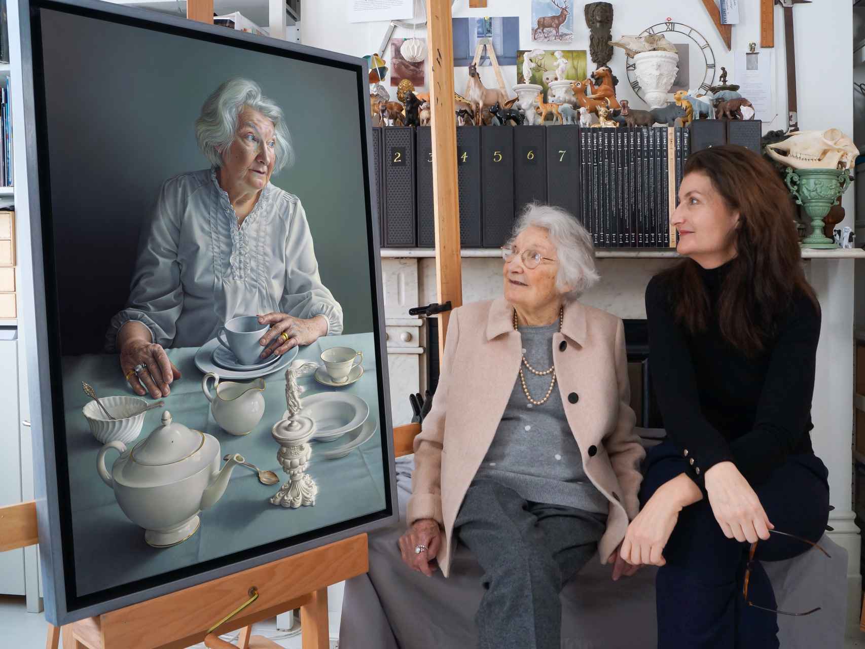 Alma y Miriam posan junto al retrato que la pintora le hizo a su madre.