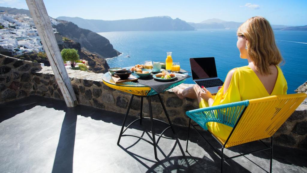 Mujer desayunando frente al mar.