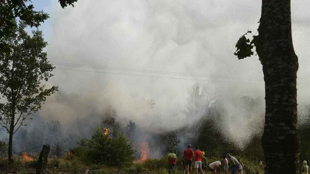 Varias personas trabajan en la extinción de un incendio en Verín (Ourense).